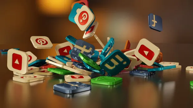 3D illustration of colorful social media icons like YouTube, Pinterest, LinkedIn, and Facebook scattered and falling on a reflective surface. Represents the variety of platforms available for social login integration.